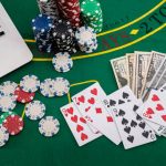 poker chips with banknotes placed on a laptop keyboard. Poker concept