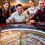 Excited group of friends playing roulette in casino