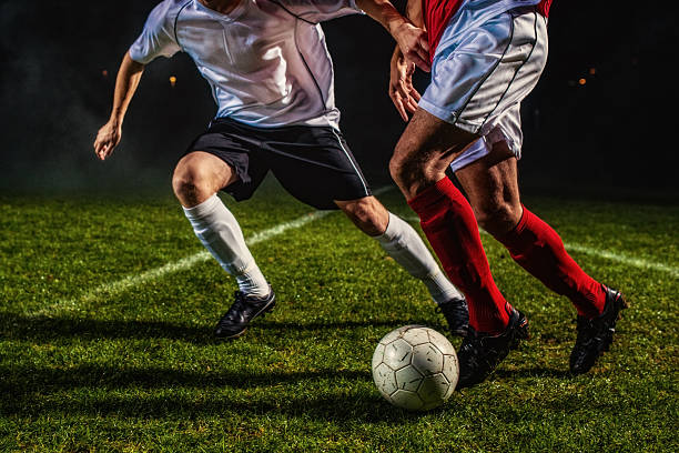 Two soccer players challenging for the ball, low angle view.